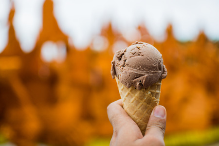 Closeup on a brown chocolate icecream, in a handの写真素材