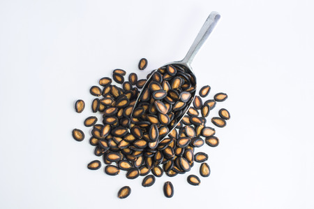 Watermelon seeds in aluminum spoon on white backgroundの写真素材