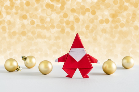 Santa Claus paper craft and golden ball with lights snow winter background. Paper origami.の写真素材