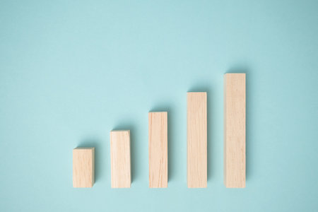 Minimal wooden blocks graph steps on blue background. Business growth process, profit, investment,...