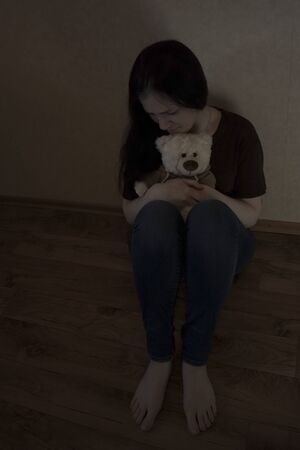 Depressed girl sitting alone on the floorの写真素材