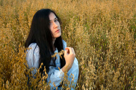 girl in a wheat field with a spikeletの写真素材
