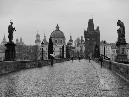 Karluv most The Charles bridge early in the morning, black and white, drizzle on the bridge people with umbrellas, november, autumnのeditorial素材