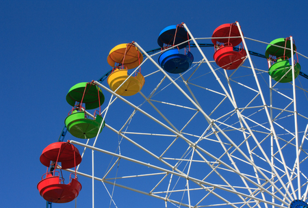 Big wheel with colored cabins against the skyの写真素材