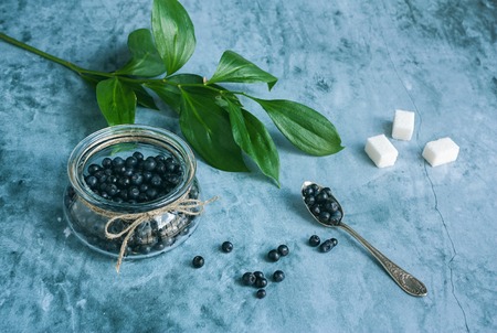 Glass jar and little spoon with blueberriesの写真素材