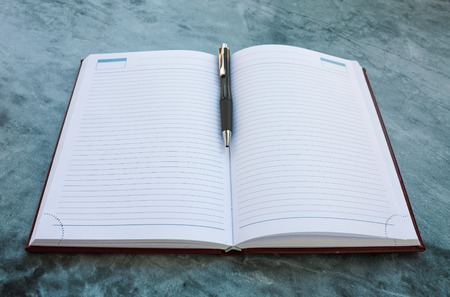 Writing accessories on the table: notebook and pen