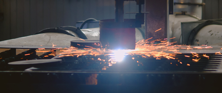 Plasma cutting machine in the process of work with departing bright sparks