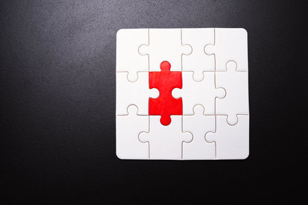 Red puzzle piece completing the jigsaw symbolizing a business problem solution. The puzzle is...