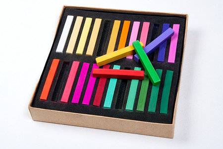 Close up view of the colorful chalk pastels and box on the white background.の写真素材