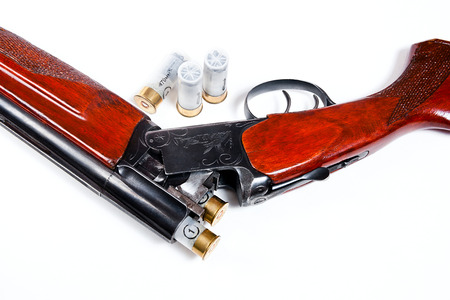 Hunting shotgun and ammunition on white background. Cartridges for hunting rifle. Close up view...