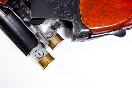 Hunting shotgun and ammunition on white background. Cartridges for hunting rifle. Close up view...