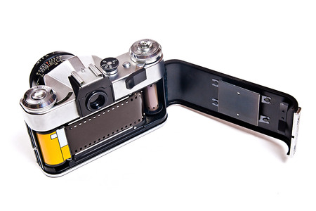 Range finder photo camera with lens. Photo film in cartridge. Back view of classic black manual film...