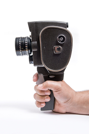 Old movie camera with lens in hand isolated on a white background.の写真素材
