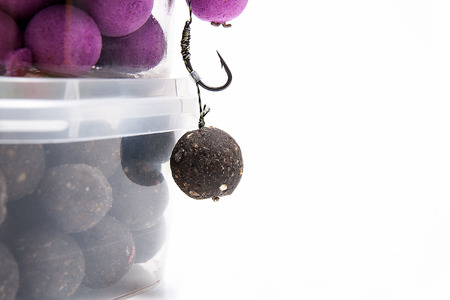 Close up view of fishing baits and Fishing gear for carp. Accessories for carp fishing. View of ready for use fishing hook with carp boilies, dry feed for carp fishing and different boilies isolated on white background.の写真素材