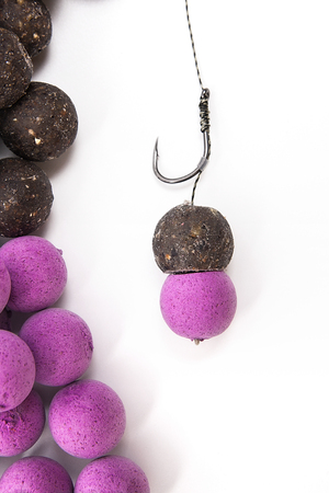 Close up view of fishing baits and Fishing gear for carp. Accessories for carp fishing. View of ready for use fishing hook with carp boilies, dry feed for carp fishing and different boilies isolated on white background.の写真素材