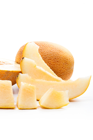 Close up view of whole, half and sliced ripe juicy melon tropical fruit at summer time isolated on a white backgroundの写真素材