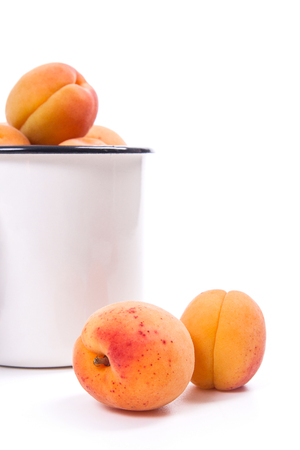 Group of harvested ripe apricots in white cup and whole and halved apricots isolated on white background. Healthy food concept. Harvest time.
の写真素材