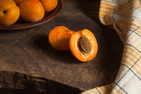 Halves of apricot with clay plate with whole apricot on background. Composition on vintage wooden background.の写真素材
