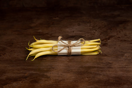 Bunch of raw yellow pods of haricot on wooden background. French beans or Green beans also known as String beans from India. Vegetables collection.の写真素材
