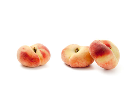 Three ripe chinese flat peach fruits or saturn peaches with soft shadow isolated on white background with clipping path.の写真素材