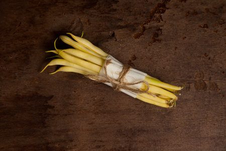 Bunch of raw yellow pods of haricot on wooden background. French beans or Green beans also known as String beans from India. Vegetables collection.の写真素材