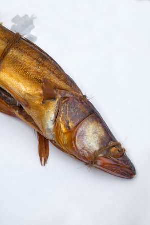 Appetizing smoked freshwater zander fish in smokehouse. Beautiful delicious dried smoked fish with...