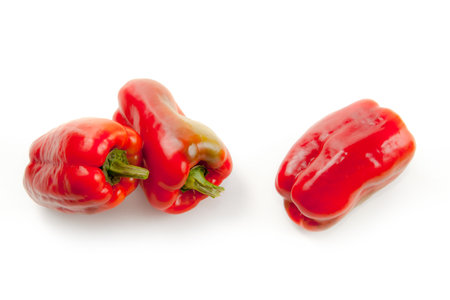 Three whole red bell pepper (capsicum) known as sweet bell pepper, paprika isolated on white background with clipping path.の写真素材