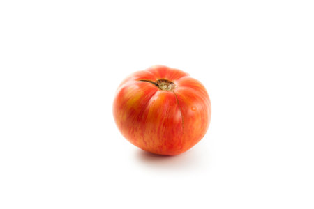 Whole ripe juicy pink tomato with soft shadow isolated on white background with clipping path. Vegetables collection on white.の写真素材