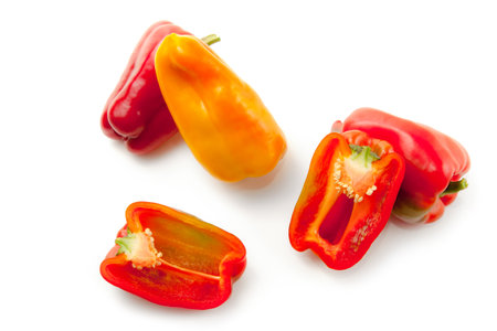 Whole and halves of red and yellow bell pepper (capsicum) known as sweet bell pepper, paprika isolated on white background with clipping path.の写真素材
