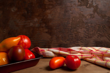 Vegetable background image. Assort of different shape and color whole ripe juicy tomatoes on vintage wooden background.の写真素材