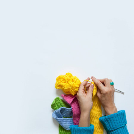 Woman knitting needles colored fabric. View from above. White background.の写真素材