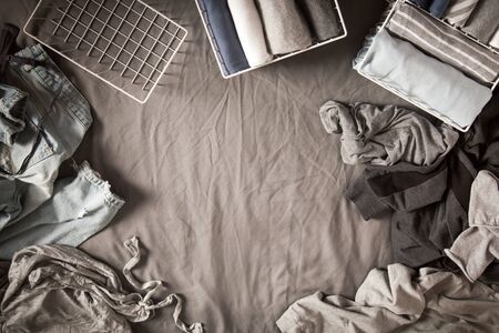 Spring cleaning of closet. Vertical tidying up storage. Neatly folded clothes in the metal white...