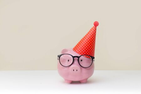 A pink piggy bank in glasses at a party.の写真素材