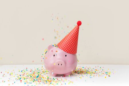 A pink piggy bank in glasses at a party.の写真素材