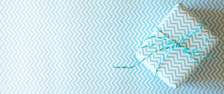 Light blue gift with ribbon on the white background with wave