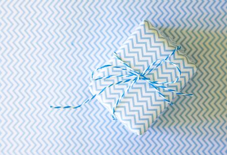 Light blue gift with ribbon on the white background with wave