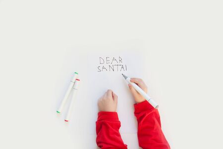 child writes a letter to Santa Claus. gift boxes, snowflakes, tree, white backgroundの写真素材