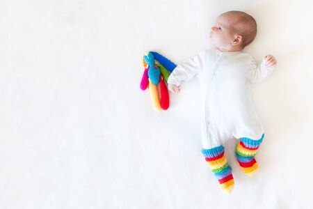 A small newborn boy lies on the bed. White background.の写真素材