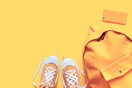 Short low bright sneakers on a yellow background.