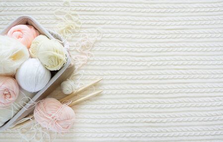 Yarn in a basket of beige and neutral, natural tones, knitting and crocheting. Spokes, succulent, scissors. White background.の写真素材