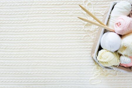 Yarn in a basket of beige and neutral, natural tones, knitting and crocheting. Spokes, succulent,...