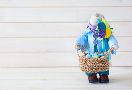 Handmade toys. Easter rabbit. Multicolored eggs. White background. Nest with eggs.の写真素材