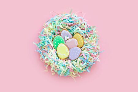Sweets for celebrate Easter. Gingerbread in shape of easter bunny and easter eggs. White and color background top view copy spaceの写真素材