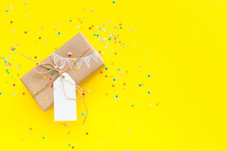 Colored gift boxes with jute rope. Yellow background. Gifts for party or a birthday.の写真素材