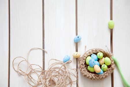 A woman makes a nest for Easter eggs. Easter bunny. White background. A handmade toy. Top view