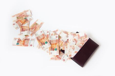 Russian money falls out of the purse. A pile of banknotes of five thousand rubles.