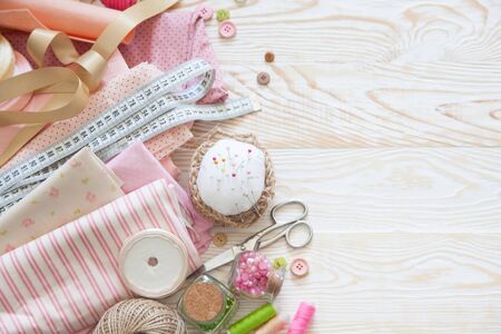 Many different materials for needlework and sewing. A girl / woman is drinking coffee cappuccino.