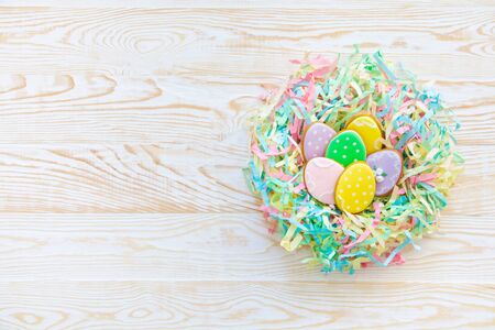 Sweets for celebrate Easter. Gingerbread in shape of easter bunny and easter eggs. White and color background top view copy spaceの写真素材