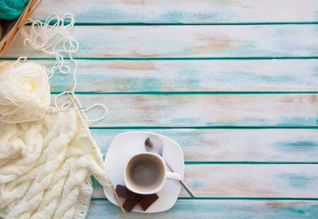 Woolen knitted fabric from yarn. Turquoise old aged new background. Black coffee and chocolate.