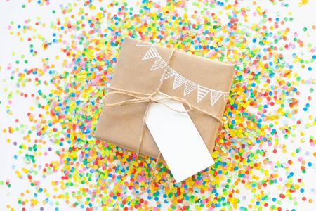 White gift box. Drawing of a white garland, flags. White background. Confetti.